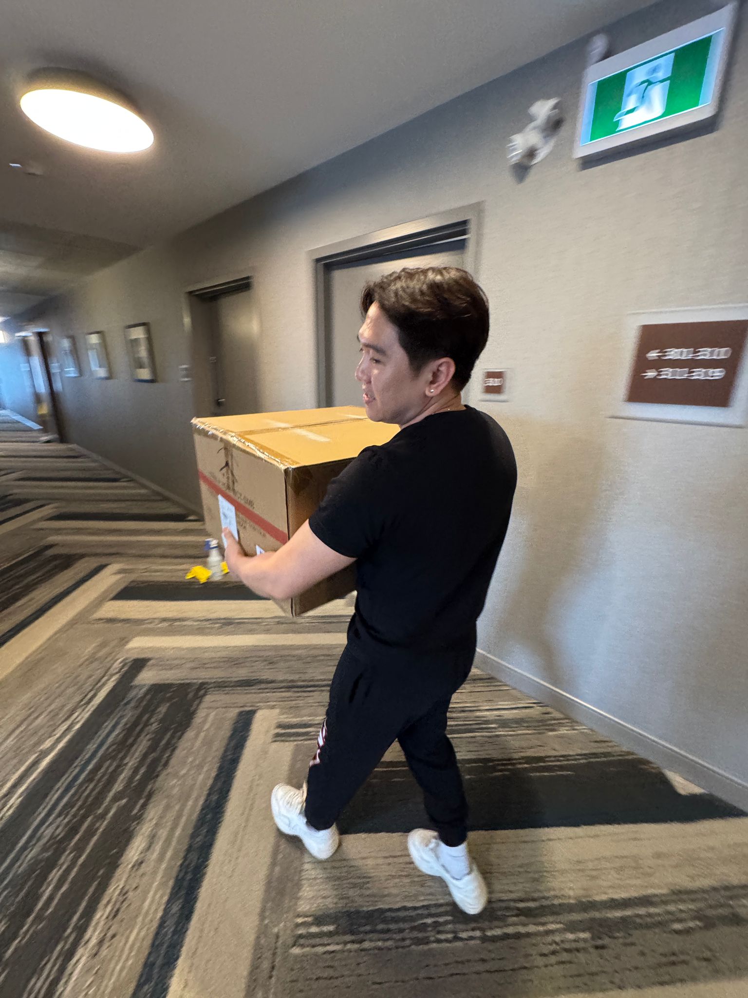 Houseperson carrying supplies in hotel corridor